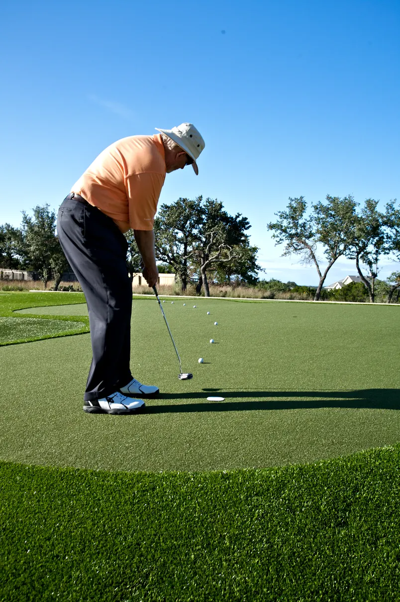 Golfer putting on an artificial putting green