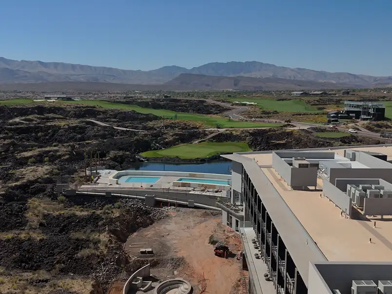 Aerial view of a waterfront property with an artificial lawn and putting green