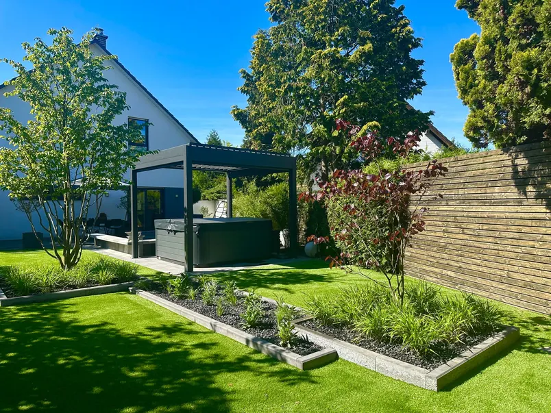Modern backyard with a pergola, raised garden beds, and artificial lawn