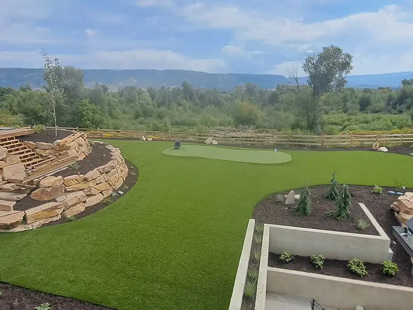 Small backyard pool surrounded by artificial grass and mountain views