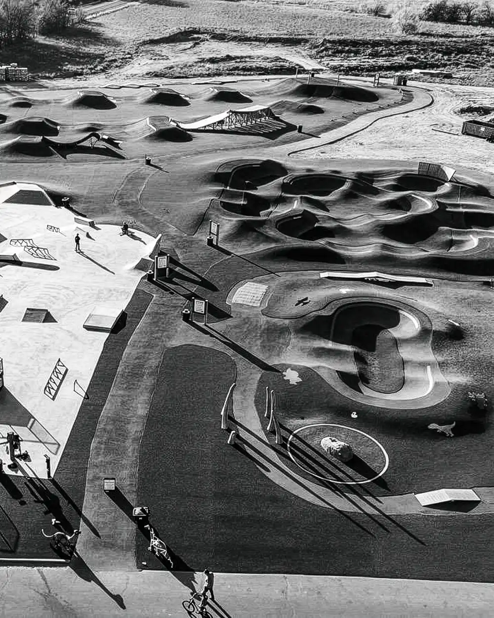 Aerial view of a bike pump track and skate park landscaped with artificial turf